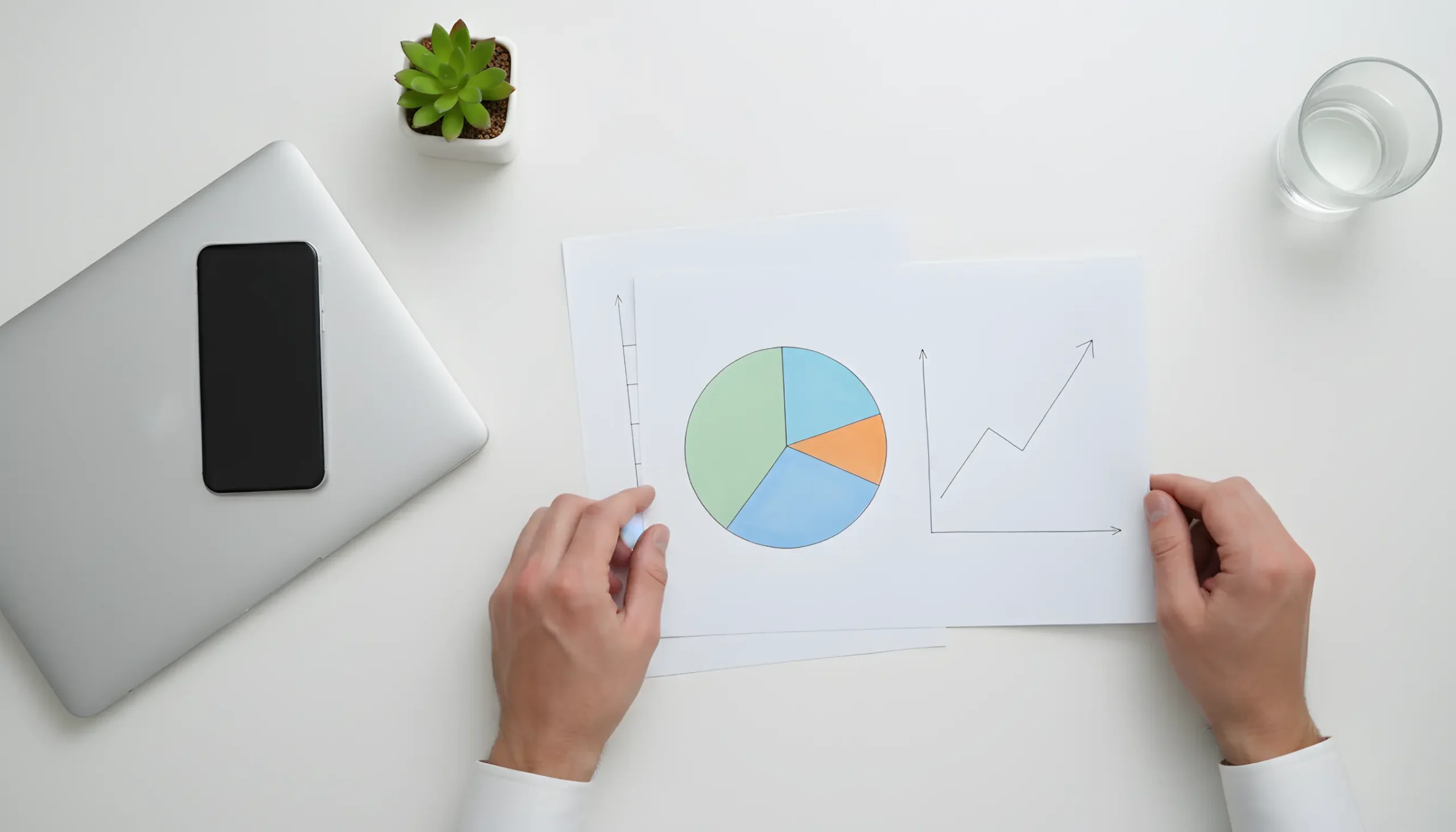 Área de trabalho organizada com documentos e gráficos simples representando planeamento de banca